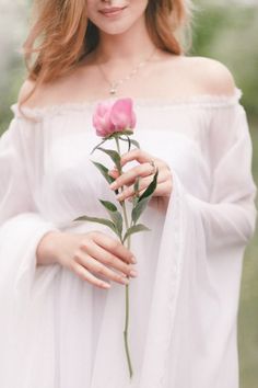 a woman holding a flower in her hand