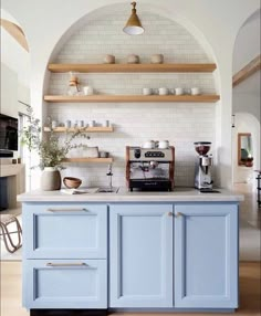 a kitchen with blue cabinets and shelves on the wall