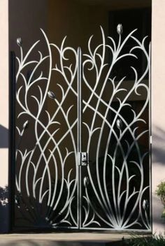 an intricately designed metal door is shown in front of a stucco wall and planter