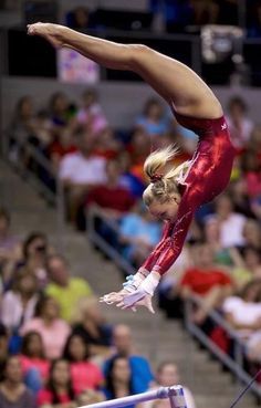 a woman on the balance beam in front of an audience