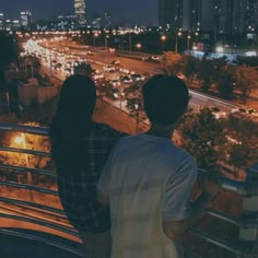 two people looking out over the city at night