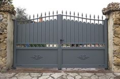 an iron gate with stone pillars is shown