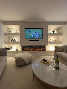 a living room filled with furniture and a flat screen tv mounted on the wall above a fire place