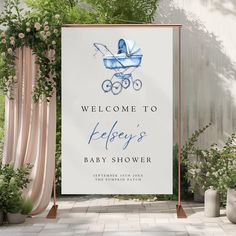 a welcome sign for a baby's shower is displayed in front of some potted plants