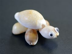 a small figurine of a turtle on a black surface with other items around it