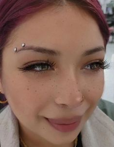 a woman with piercings on her forehead