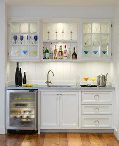 a kitchen with white cabinets and wooden floors