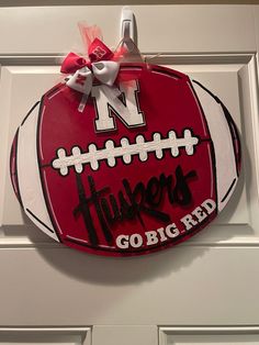 a football shaped door hanger with the words, university go big red