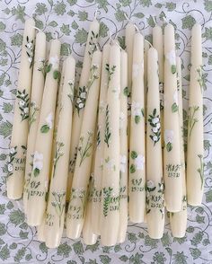 eight candles with floral designs on them sitting on a table