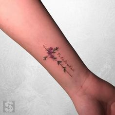 a small wrist tattoo with flowers on it