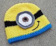 a crocheted yellow and blue hat with a smiley face on it's side