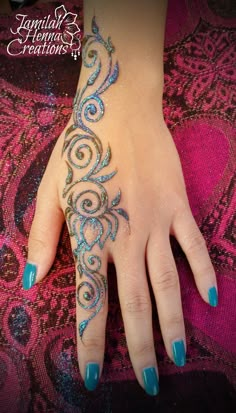 a woman's hand with blue and silver designs on it