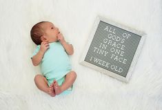 a baby is laying down next to a sign