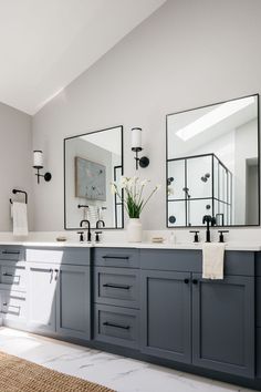 a bathroom with two sinks and mirrors on the wall