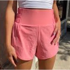 These Highwaisted Running Shorts Are Functional But Still Fashionable, Featuring Scalloped Detail On The Side, Inner Lining, And A Partially Ruched Waistband Detail. Perfect For Heading To The Gym, Running Errands, Or A Casual Day Out. Super Cute And Comfy!, Nwt Pink/Coral Fits True To Size Inner Lining Partially Ruched Waistband Size Small Inseam: 3.75" Self: 88% Nylon, 10% Spandex Inner Lining: 80% Polyester, 20% Spandex Machine Wash Cold | Tumble Dry Low Sporty Running Bottoms With Built-in Shorts, Sportswear Bottoms With Built-in Shorts For Workout, Relaxed Fit Sportswear With Built-in Shorts, Sportswear Bottoms With Built-in Shorts, Casual Biker Shorts With Built-in Shorts For Training, High Waist Bottoms With Built-in Shorts For Running, Summer Training Bottoms With Built-in Shorts, Athletic Bottoms With Built-in Shorts For Sports, Sporty High-waisted Shorts With Ribbed Waistband