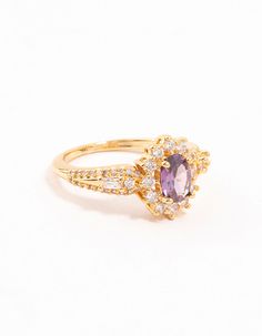 This stylish ring will infuse your looks with regal style. It features a gold base and a halo-style purple cubic zirconia crystal adorned with a halo of sparkling cubic zirconia crystals, perfect for an opulent, enchanting look. Material: Crystal, Cubic Zirconia Color: Purple Dimensions: Diameter 16 mm x Band Width 2 mm Feature Dimensions: Feature Width 9 mm x Feature Length 10 mm | Lovisa Gold Opulent Purple Cubic Zirconia Statement Ring, Size: XS/S, Clear Gold Amethyst Ring With Cubic Zirconia For Promise, Halo Style, Stylish Rings, Cubic Zirconia, Halo, Statement Rings, Sparkle, Engagement Rings, Band