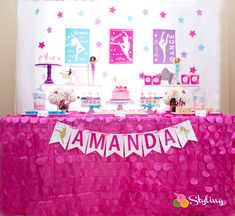 a pink table topped with cake and desserts