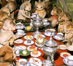 a group of stuffed animals sitting around a table with tea cups and saucers on it