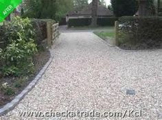 a gravel driveway leading to a house