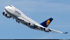 a large jetliner flying through a blue sky with its landing gear down and two engines out