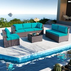 an outdoor living room with furniture by the water