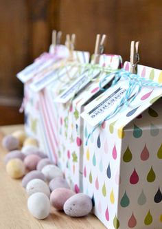 several small boxes are lined up next to each other on a table with eggs and clothes pins