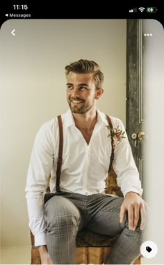 a man sitting on top of a wooden chair wearing suspenders and a white shirt