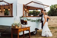 a bride and groom standing in front of a food truck