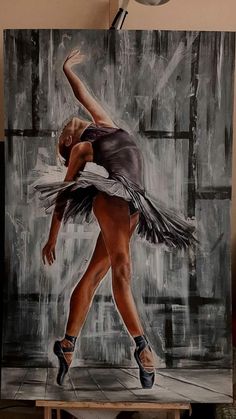 a painting of a ballerina in black and white is shown on a easel