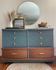 a dresser with two drawers and a mirror above it