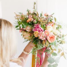 a woman holding a bouquet of flowers in her hands