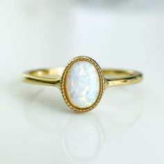 A dreamy and romantic opal ring featuring a round cut in a bezel setting and an elegant polished band in 14K gold plating over sterling silver.
A delicate vintage design and a glowing opal stone make this a truly unique piece. Vintage Wedding Rings Opal, Big Opal Ring, Adjustable Gold Opal Ring Fine Jewelry, Anniversary Opal Ring Stamped 14k In Oval Shape, Gold 14k Opal Ring As Gift, 14k Gold Opal Ring For Gift, Oval Gemstone Gold Stackable Rings, 14k Gold Stackable Opal Promise Ring, Elegant Adjustable Moonstone Ring With Round Stone