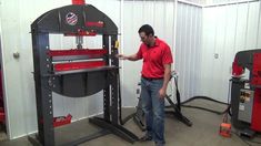 a man standing in front of a red and black work bench with tools on it