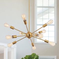 a chandelier hanging from the ceiling in a room with white walls and windows