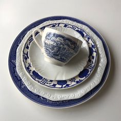 a blue and white plate topped with a cup and saucer