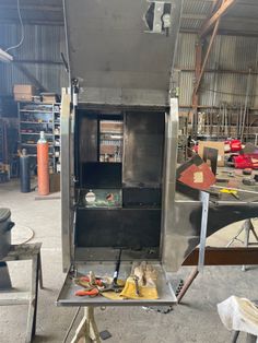 the inside of a metal cabinet with tools on it in a garage area next to other items