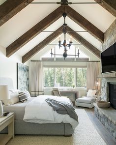 a bedroom with a large bed sitting under a vaulted ceiling