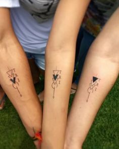 two people with matching tattoos on their arms and legs, both holding each other's hands