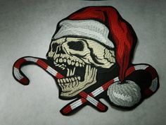 a pirate skull with a santa hat and crossed sabers on it's side