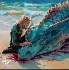 a woman is painting a dragon on the beach