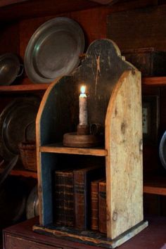 an old book shelf with a lit candle in it