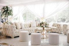 a living room filled with lots of white furniture