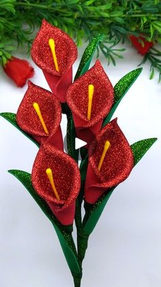 red flowers with green leaves on white surface