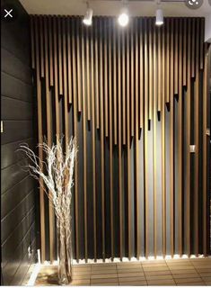 a vase with some flowers in it next to a wooden paneled wall that has vertical slats on it