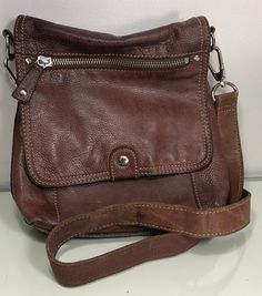 This beautiful Fossil brown leather purse is versatile enough to be used as a cross body bag or over the shoulder purse. With zippered storage compartments to fit all of your necessities, you can go out in style and have the function that you need. This purse measures approximately 9.5" across, 9.5" tall and 3.5" deep. We promise to refund any shipping overpayment.  The condition of this item is as pictured. We try and take pictures of our products that best represent overall condition. Send us Over The Shoulder Purse, Brown Crossbody Purse, Brown Leather Purse, Brown Crossbody, Brown Handbag, Storage Compartments, Shoulder Purse, Cross Body Bag, Crossbody Purse