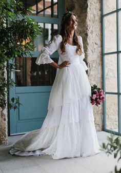 a woman in a white dress is standing outside