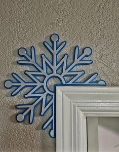 a snowflake is hanging on the wall next to a frame