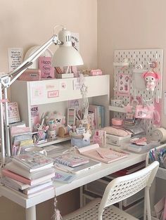 a white desk topped with lots of clutter and pink decor on top of it