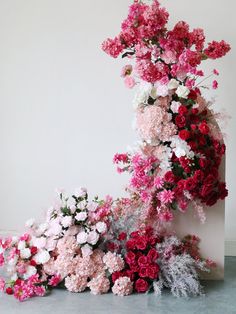 pink and white flowers are arranged on top of each other in the shape of a column