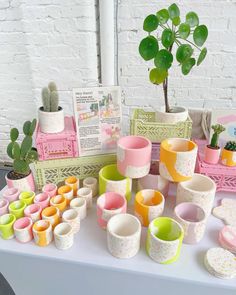 there are many cups on the table with plants in them, and some cards next to it